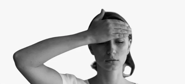 Person holding their forehead in pain from a headache